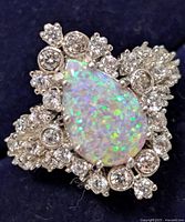 Close-up of sterling silver ring with pear-shaped opalite and surrounding cubic zirconia stones.