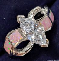 Close-up front view of silver ring showing pink opalite inlays and marquise cubic zirconia centerpiece