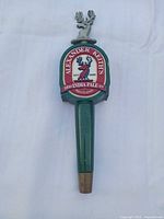 Front view of Alexander Keith's tap handle showing logo, green body, brass ferrule