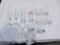 All ten glassware pieces laid out—flutes, pint, snifter, rocks glasses