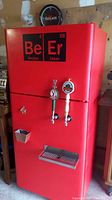 Front view of red kegerator with dual taps, drip tray, cap catcher and periodic table graphic