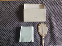 Mirror, pouch, and box laid out