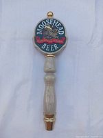 Front view of Moosehead Beer wood tap handle showing logo and full length