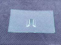 Top view of curved glass shelf showing clear surface and central mount slot