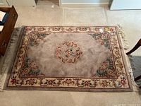 Top view of the full area rug showing the overall design and size on a beige carpet.