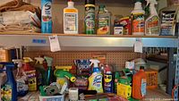 Full view of metal shelf with various cleaning, insecticides, and garden chemical containers along with Epsom salt and other boxes.