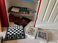 Photo showing chess set on board, backgammon set, magnetic darts, and two sealed puzzles.