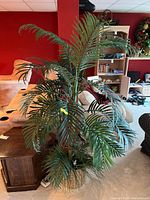 Full view of the faux palm plant with multiple green palm fronds