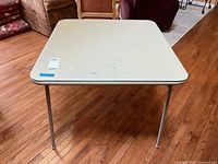 Top view of the folding table showing cream-colored surface with stains and wear marks