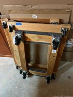 Three wooden furniture dollies stacked together showing felt padding and caster wheels.