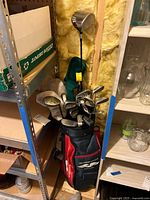 Photo of golf bag with clubs inside, showing multiple golf clubs including irons and woods with head covers.