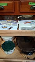 Mandolin slicer and grater sets in their boxes. Plastic containers with lids and small slow cooker visible below.