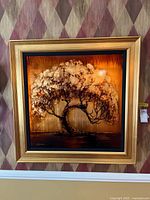 Front view of framed tree painting showing gold-tone frame and tree motif