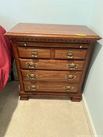 Front view of the Kincaid wooden side stand showing three drawers and brass handles