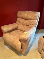 Front and angled view of beige/tan suede-like La-Z-Boy recliner chair showing padded armrests, seat and back with visible stitching.