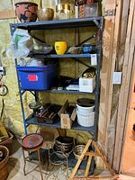 Full view of metal shelving unit, showing its five shelves and absence of any contents.