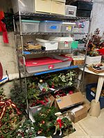 Full view of the stainless steel shelving unit filled with various boxes and decorations, showing the structure and number of shelves.