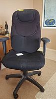 Front view of black cushioned office chair with armrests and mesh back panel, includes seat cushion placed on chair.