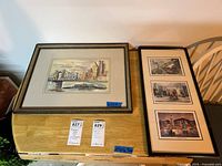 Two framed artworks on a wooden surface including one watercolor and one frame containing three prints.