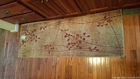 Full view of rectangular area rug showing overall vine and leaf pattern on beige background.
