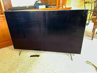 Front view of TV on stand with remote placed in front