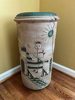 Side view showing the figure on horseback holding a pitchfork and the sun with spiked rays, texture and damage on the rim visible