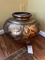 Front view showing round shape and gold-embossed floral design