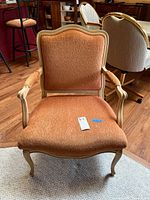 Full front view of vintage wooden frame chair with burnt orange upholstery showing fabric texture and chair shape