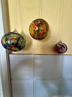 Three glass balls hanging to show colour and loops