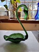 Side view of green glass swan dish showing neck and bowl