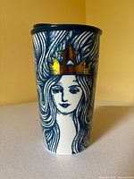 Front view showing mermaid siren with gold crown and lid