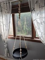 Full view of macrame hanger suspended, showing overall length and tray
