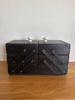 Closed sewing box showing exterior finish and porcelain knobs placed on lids