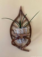Front view of rattan and wood wall plant hanger with basket