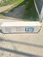 Boxed 10 x 13 foot screen house packaging photo on concrete ground in daylight