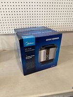 Photo showing front and top of Midea 4000 Series 20-Cup Rice Cooker box with product image and branding.