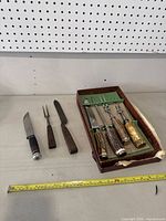 Full overview of the lot showing three knives and fork with wooden handles and a set of four carving utensils with antler handles in box