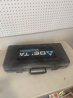 Closed black hard plastic case with Delta Shopmaster logo stamped on top