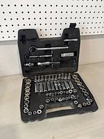 Photo of open black molded plastic case showing layout of sockets, ratchets, and extension bars.