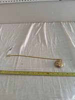 Full view of pocket watch with attached gold-tone chain laid out with measuring tape for size reference.