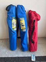 Three folding chairs in fabric carry bags, two bags blue with Escape brand labels and one red without visible brand.