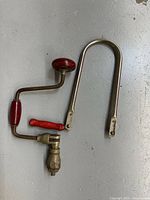 Hand brace drill and coping saw frame side by side