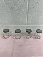 front view of all four glass spice jars with lids