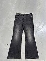 Front view of black flared jeans laid flat