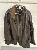 Front view of brown Danier leather jacket on hanger