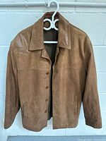 Front view of brown leather jacket on hanger