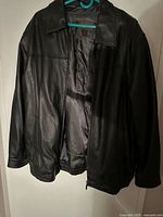 Front view of black leather Danier jacket hanging open