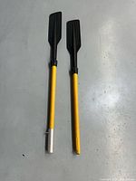 Two 46 in yellow-shaft boat oars with black blades