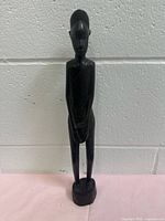 Front view of carved ebony male figure holding drum