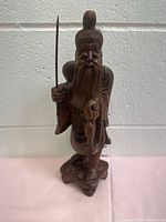 Full view of front of carved fisherman holding rod and fish